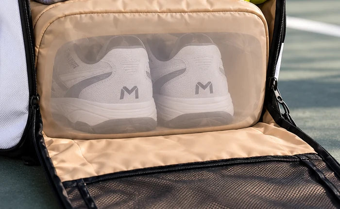 Enclosed shoe compartment shown transparent to reveal shoes inside; access is underneath the bag.