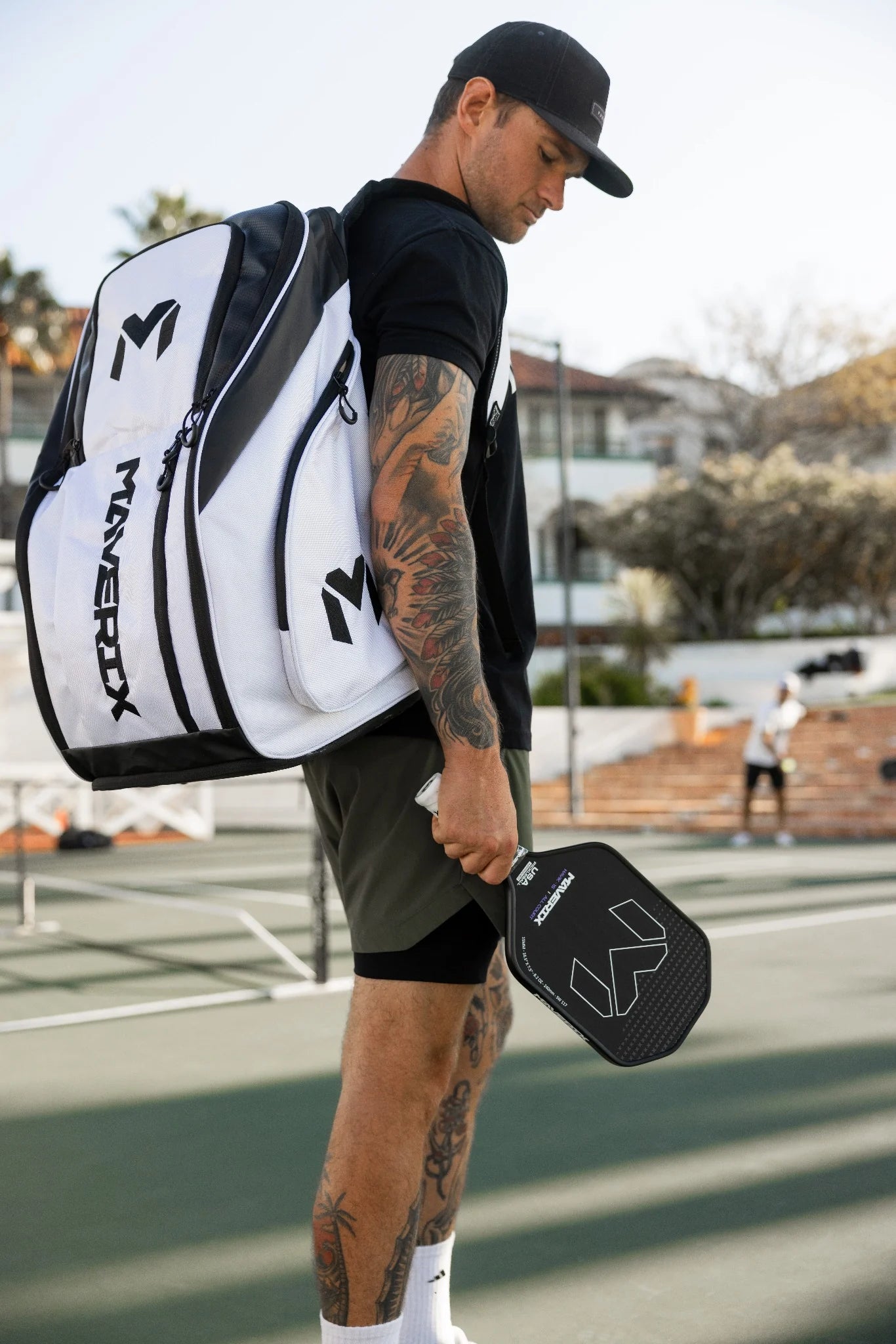 Player wearing the oversized white and black Titan Tour Pro backpack at the court.