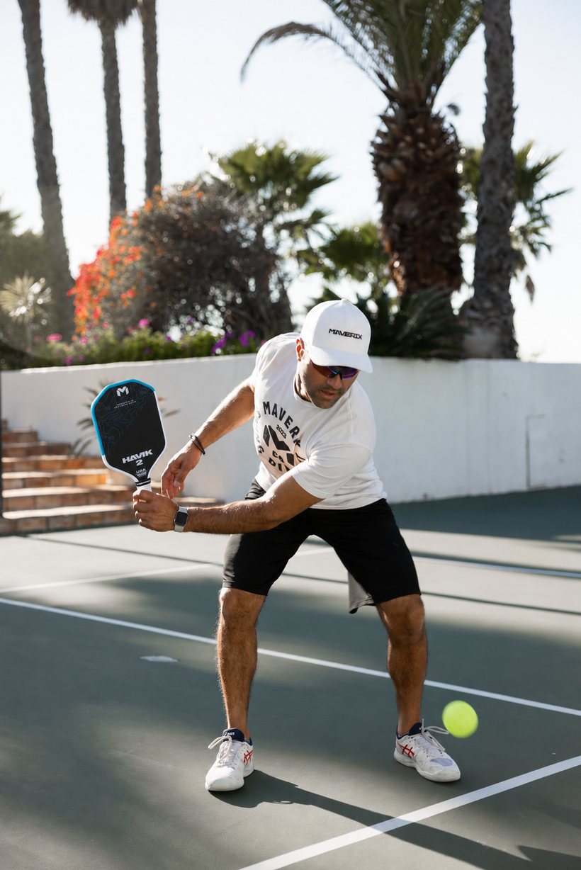 Player preparing a backhand with the blue Maverix Havik 2 paddle