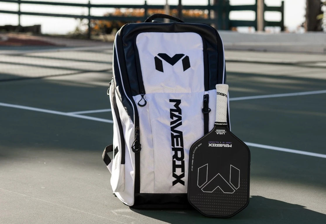 White and black Titan Tour Pro backpack on a pickleball court.