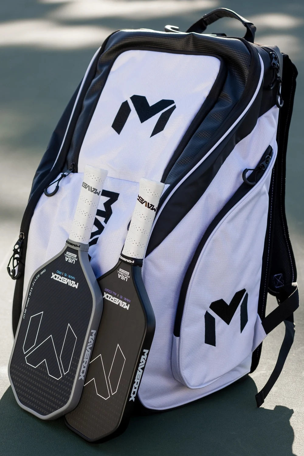 Titan Tour Pro backpack with two Maverix paddles on the court.